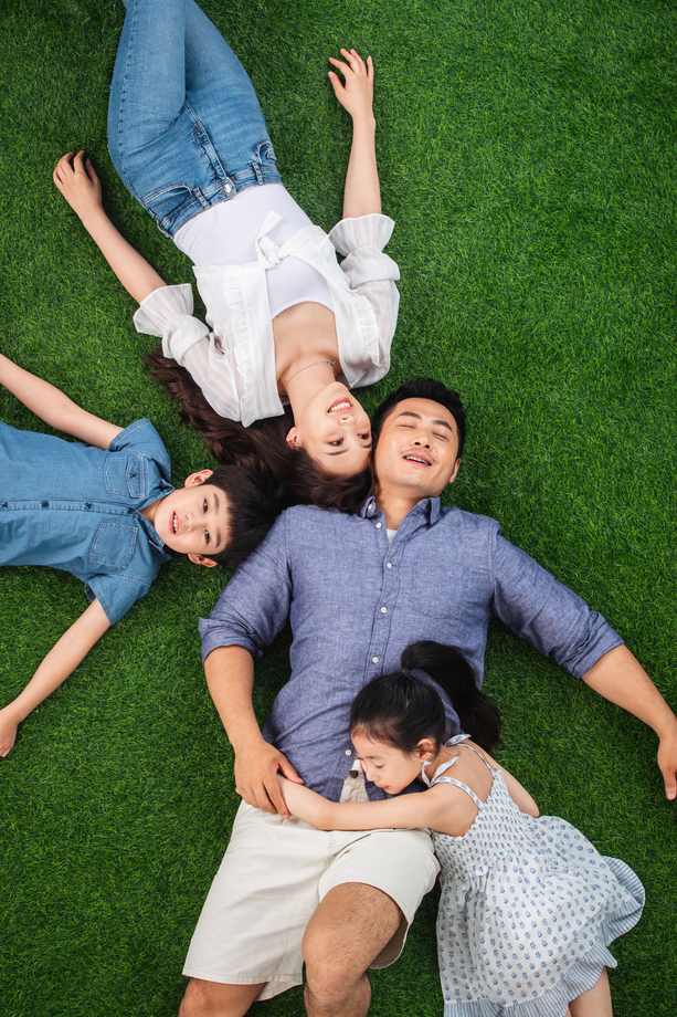 幸福的一家四口躺在草地上休息