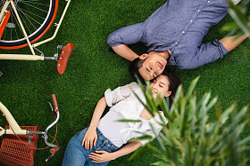 幸福的青年伴侣躺在草地上享受亲密时光