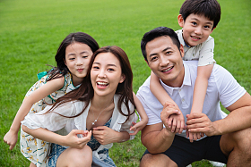 草地上快乐的一家四口照片