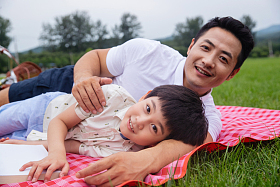 躺在野餐垫上的快乐父子