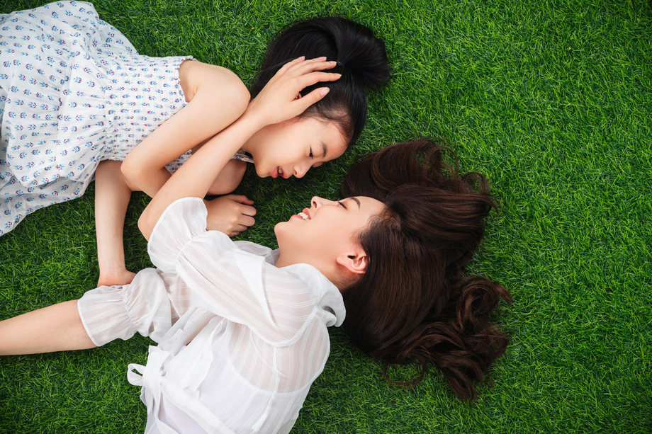 幸福的母女躺在草地上 幸福的母女躺在草地上