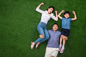 在草地上青年男人驮着妻子和儿子