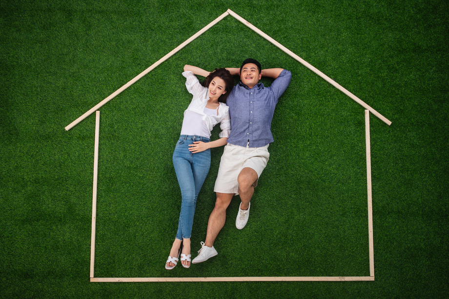 青年伴侣躺在草地上的房子轮廓 青年伴侣躺在草地上的房子轮廓