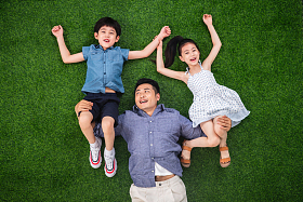 在草地上父亲托举儿子和女儿图片