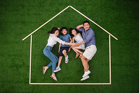 快乐的一家四口躺在草地上的房子轮廓