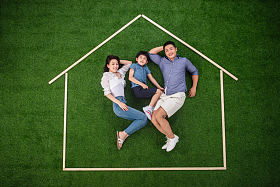 快乐的一家三口躺在草地上的房子轮廓