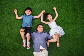 在草地上父亲托举儿子和女儿图片