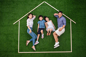 快乐的一家四口躺在草地上的房子轮廓