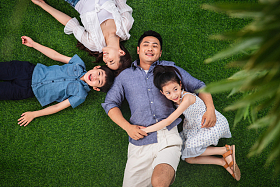 幸福的一家四口躺在草地上图片