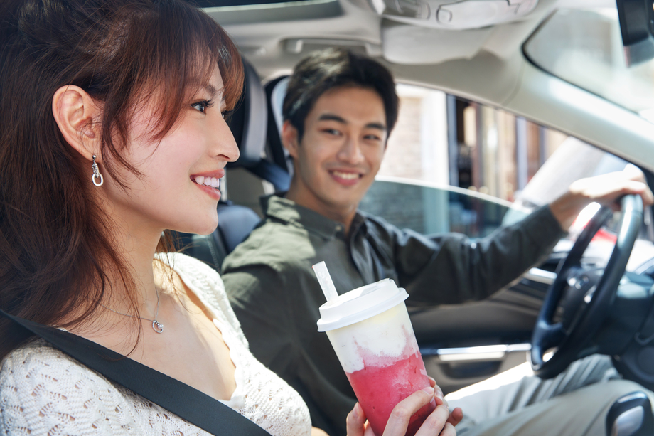 青年伴侣坐在汽车里喝饮料图片 青年伴侣坐在汽车里喝饮料图片