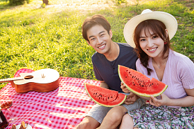 坐在草地上吃西瓜的幸福情侣图片
