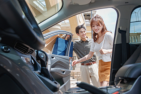 拿着购物袋站在汽车旁的幸福情侣