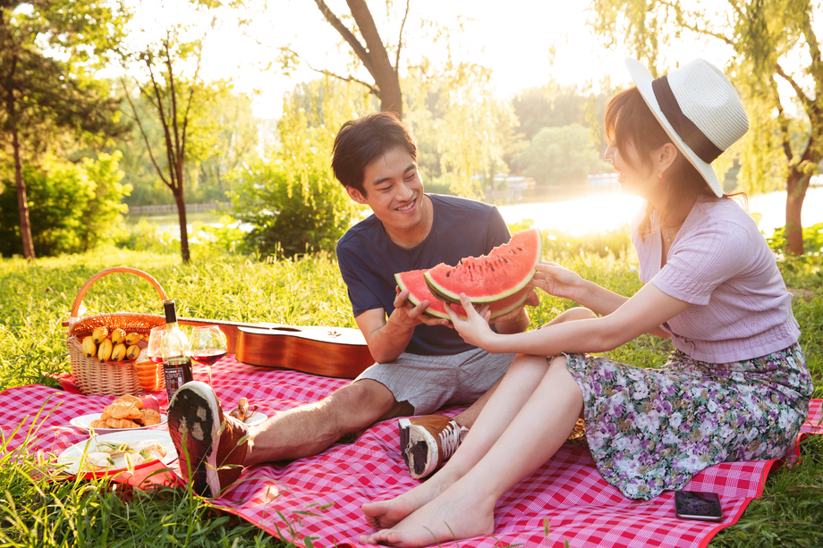 青年情侣坐在公园里吃西瓜 青年情侣坐在公园里吃西瓜