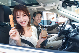 坐在汽车里的青年情侣吃东西照片