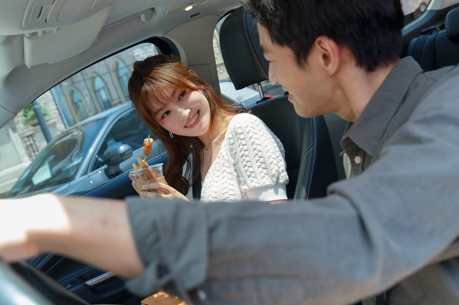 坐在汽车里的青年情侣吃东西图片