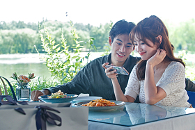 青年情侣在餐厅里用手机拍照照片