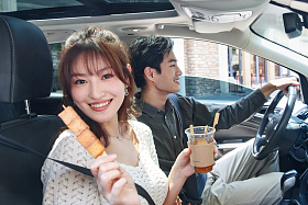 坐在汽车里的青年情侣吃东西