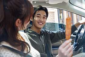 坐在汽车里的青年情侣吃东西图片