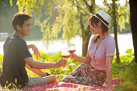 坐在草地上喝红酒的幸福情侣图片