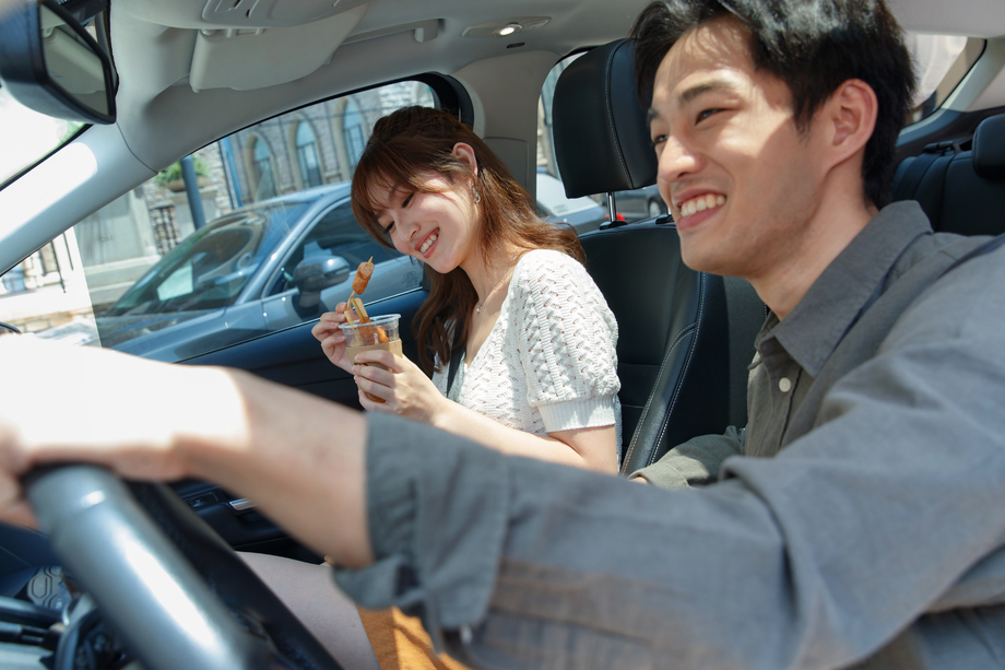 坐在汽车里的青年情侣吃东西图片