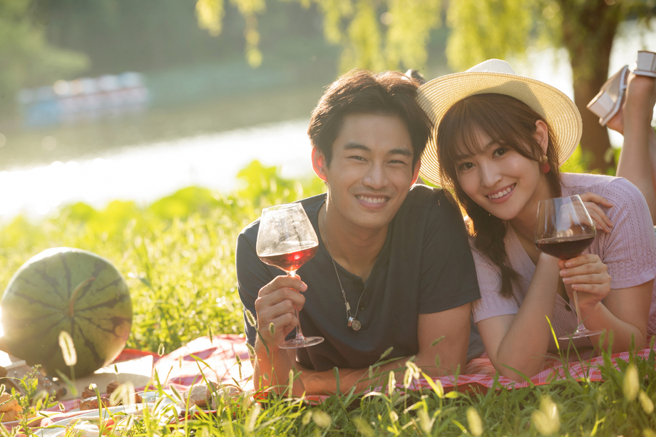 趴在草地上喝红酒的幸福情侣 趴在草地上喝红酒的幸福情侣