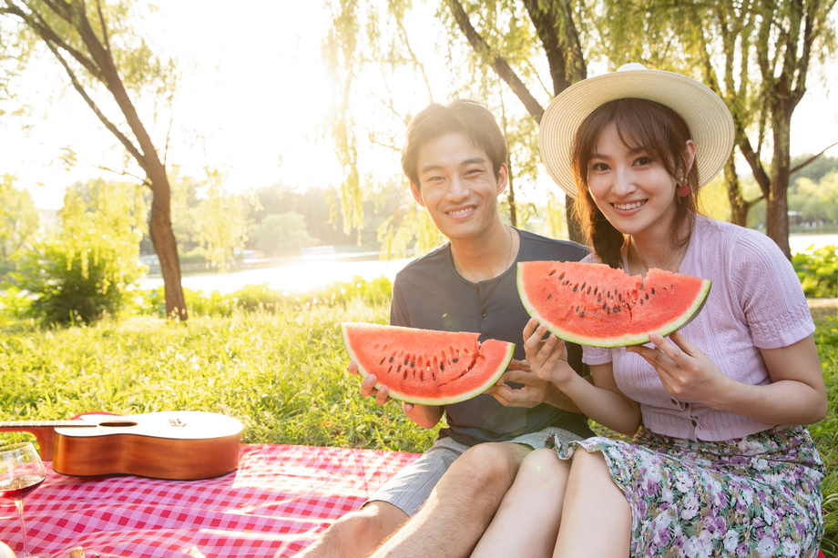 青年情侣坐在公园里吃西瓜图片 青年情侣坐在公园里吃西瓜图片
