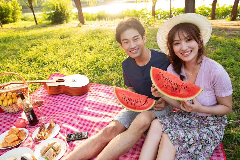 青年情侣坐在公园里吃西瓜 青年情侣坐在公园里吃西瓜