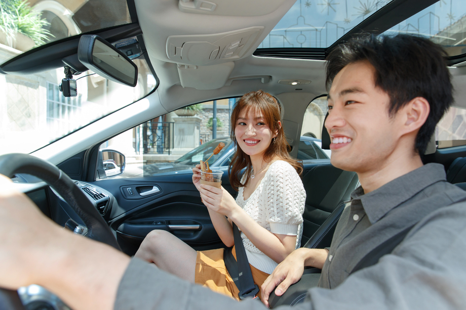 坐在汽车里的青年情侣吃东西图片