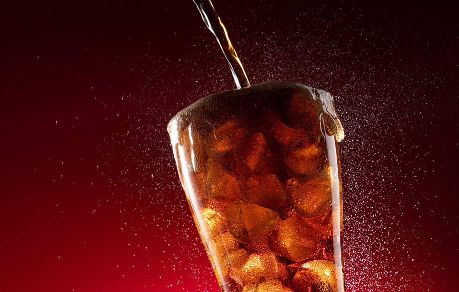 可乐倒入装满冰块的杯中照片