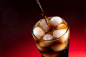 可乐倒入装满冰块的杯中图片