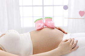 婴儿袜子放在孕妇的肚子上照片