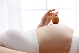 孕妇拿着牛奶放在肚子上