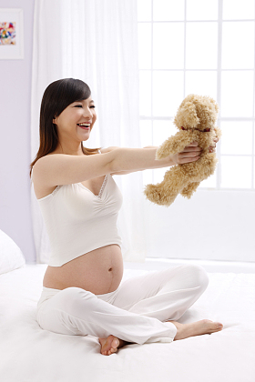 孕妇拿着玩具熊图片