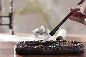 拿着毛笔写字图片