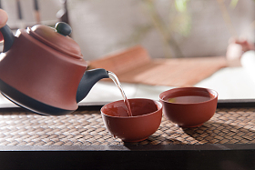 拿着茶壶倒茶图片