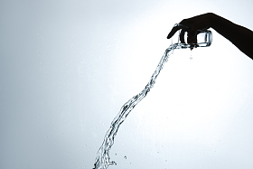 手拿杯子倒出的水花图片