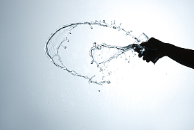 手拿杯子倒出的水花图片