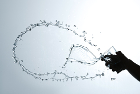 手拿杯子倒出的水花图片