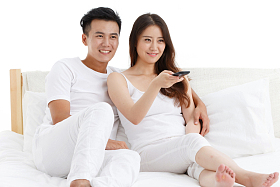 幸福的青年情侣在看电视照片