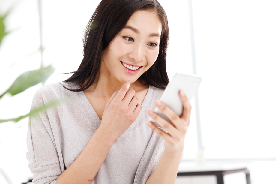 青年女人在办公室里拿着手机图片