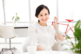 青年女人在办公室里拿着手机