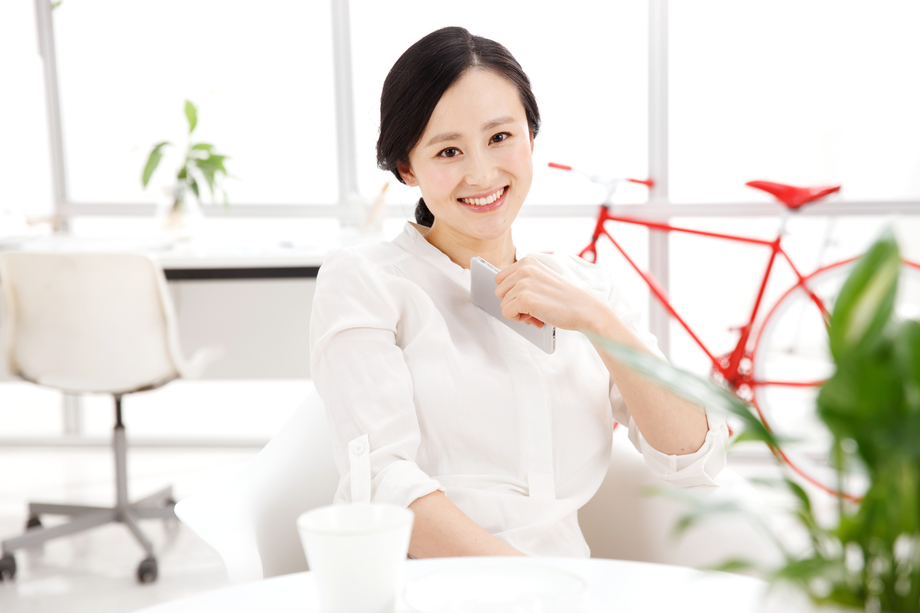 青年女人在办公室里拿着手机 青年女人在办公室里拿着手机