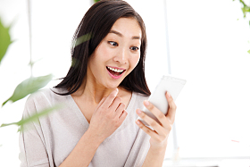 青年女人在办公室里拿着手机图片