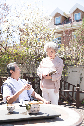 老年夫妇在庭院看书