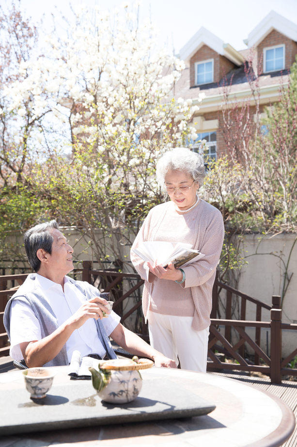 老年夫妇在庭院看书 老年夫妇在庭院看书