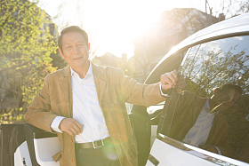 老年男人斜靠在汽车上照片