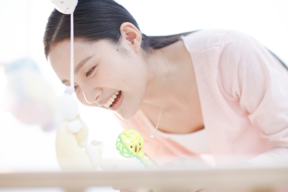 年轻妈妈在婴儿床旁图片