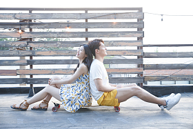 青年情侣坐在滑板上