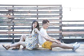 青年情侣坐在滑板上