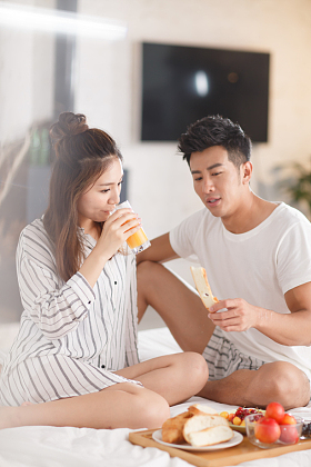 青年情侣在床上吃早餐图片